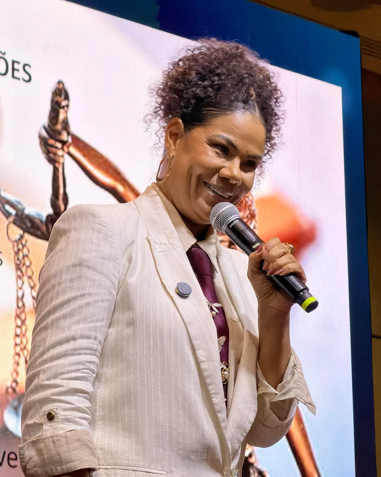Ediane Ribeiro falando ao microfone durante uma palestra